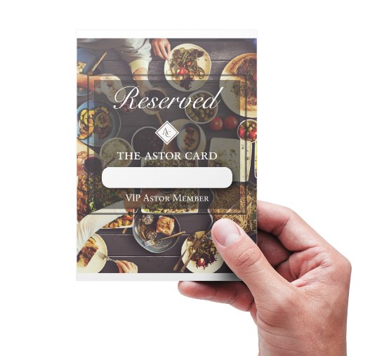 The Reserved table tent held in the hand, showing its dining photography